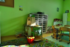 Kącik z regałami i półkami z zabawkami w sali przedszkolej
