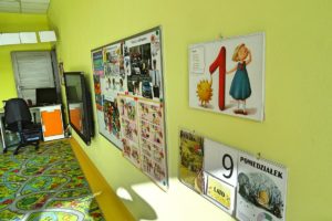 Ściana sali przedszkolen z widocznymi materiałami dydaktycznymi oraz telewizorem