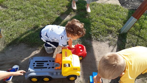 Ignaś i Igorek bawią się samochodami na placu przedszkolnym