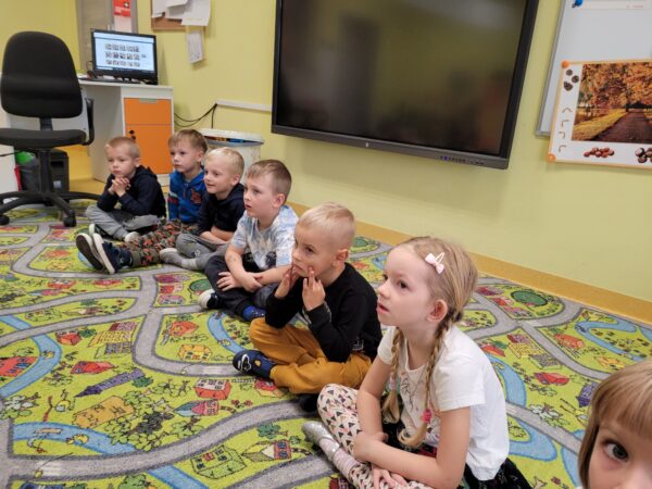 Dzieci słuchają opowieści o dinozaurach