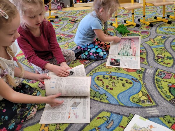 Dziewczynki ogladają ksiązki o dinozaurach
