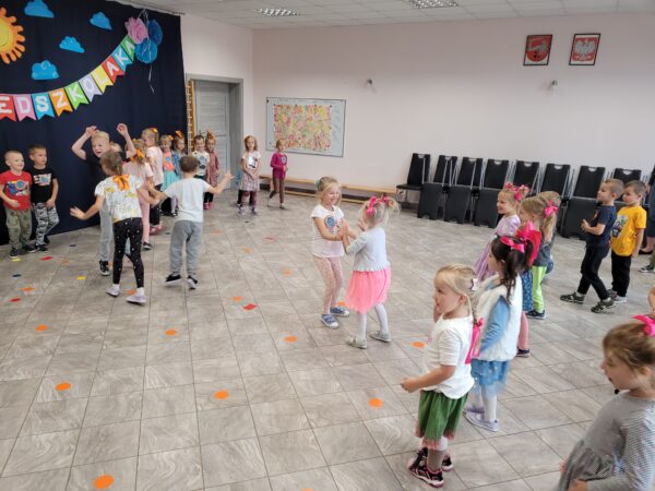 Dzieci tańczą na środku sali.