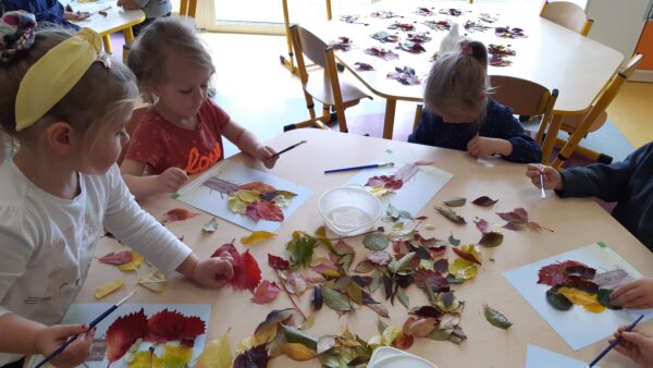 Dzieci tworzą kompozycje z jesiennych liści
