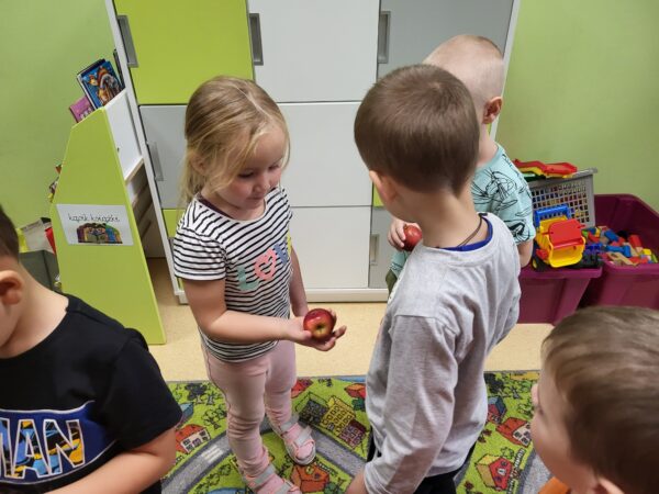 Mama Gabrysia i Mii częstuje dzieci jabłuszkami.