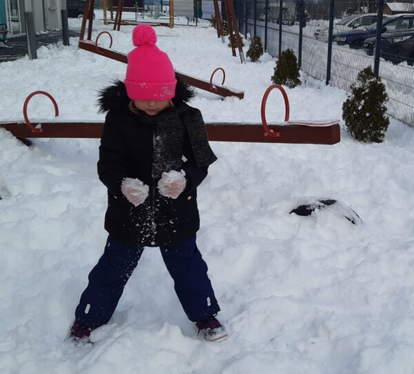 Kornelcia bawi się na śniegu