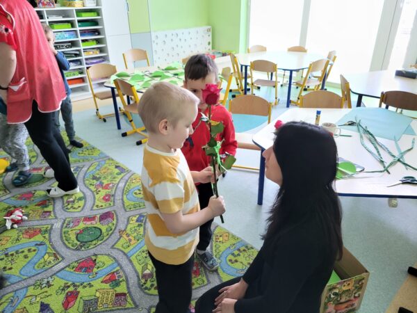 Chłopcy wręczają kwiatki Pani Monice.