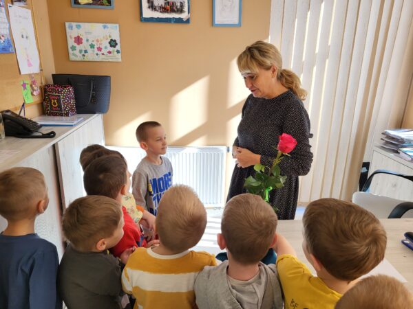 Chłopcy wręczają kwiatki Pani Dyrektor.