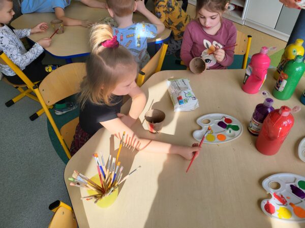 Dzieci malują doniczki.