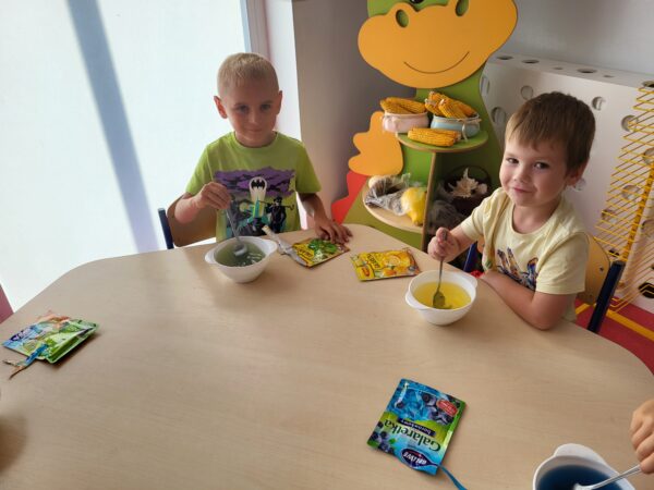 Dzieci przy stolikach mieszają galaretkę.