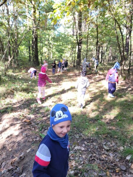 Dzieci biegają po lesie.