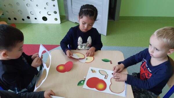 Mia, Gabryś i Oleczek składają szablon jabłuszka zgodnie z podanym wzorem