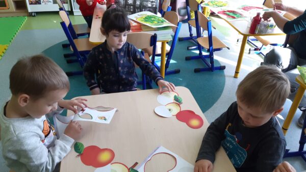 Rozalka, Jaś i Arturek składają szablon jabłuszka zgodnie z podanym wzorem