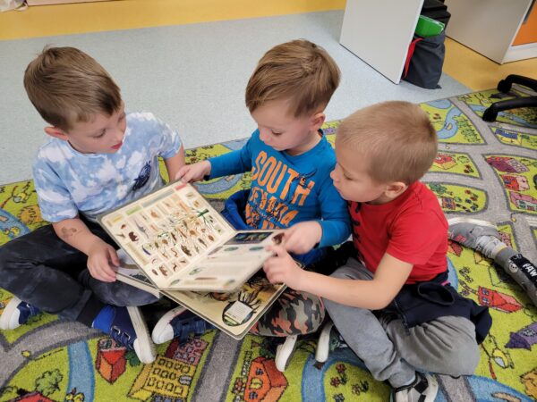 Dzieci oglądają ksiązki o dinozaurach