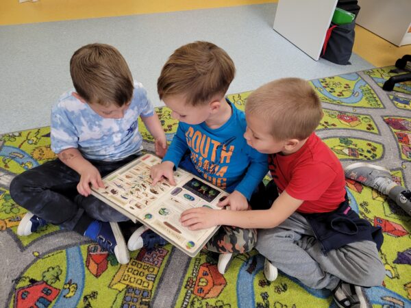 Dzieci oglądają ksiązki o dinozaurach