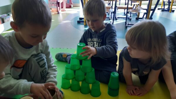 Arturek buduje zamek z kolorowych kubeczków