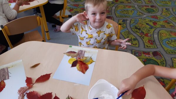 Igorek tworzy kompozycję z jesiennych liści
