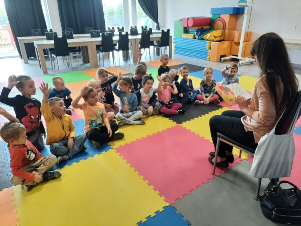 Dzieci z zainteresowaniem słuchają bajki czytanej przez mamę Lenki