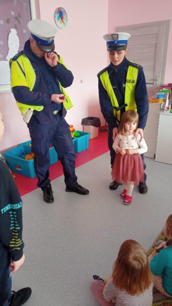 Dzieci słuchają zajęć edukacyjnych z policjantami