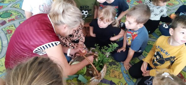 Pani Jola pokazuje dzieciom jesienne dary ze swojego ogródeczka