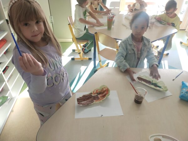 Gabrysia i Nastusia dokładnie zamalowują liście kapusty pekińskiej