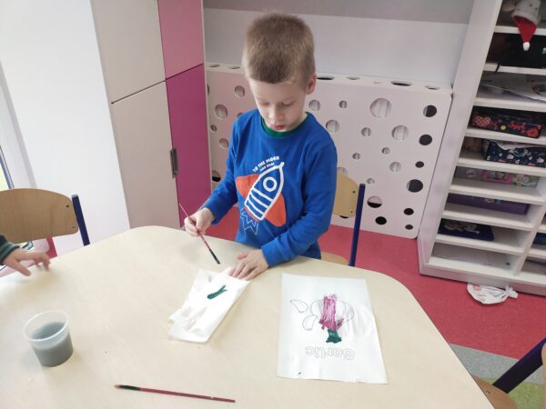 Kacper maluje liście czosnku