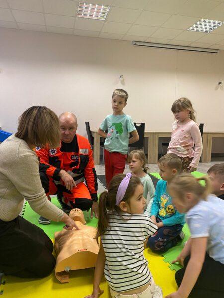 Misie biorą udział w zajęciach edukacyjnych z ratownikiem medycznym.