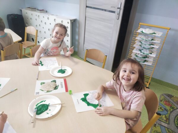 Klara i Marcela dokładnie zamalowują listki kalafiora