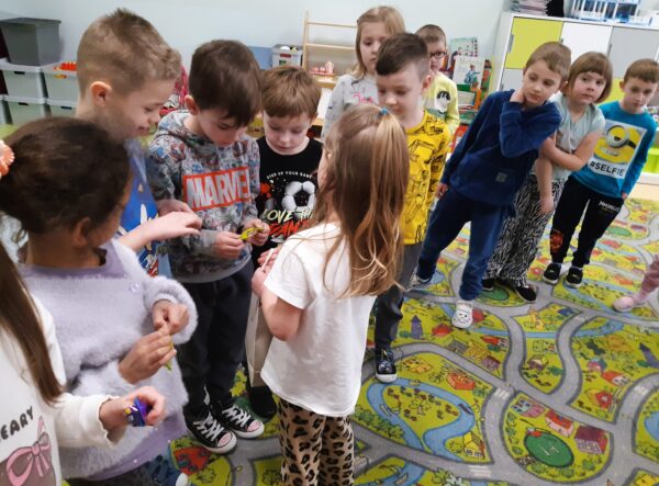 Karolcia dzieli się z dziećmi urodzinowymi słodkościami.