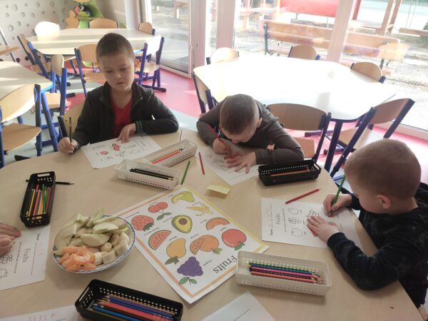 Chłopcy kolorują owoce a ulubiony owoc otaczają pętlą