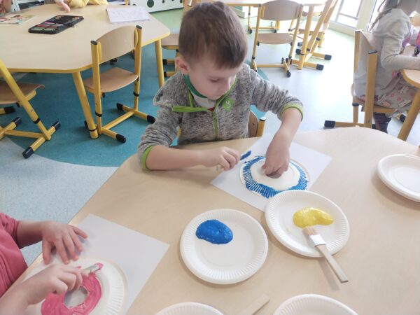 Oliwier zamalowuje wszystkie białe miejsca niebieską farbą