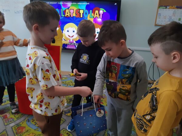 Fabian częstuje dzieci słodyczami.