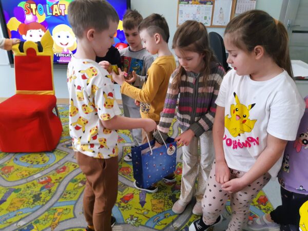 Fabian rozdaje dzieciom słodkości.