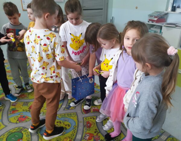 Fabian dzieli się z dziećmi urodzinowymi niespodziankami.