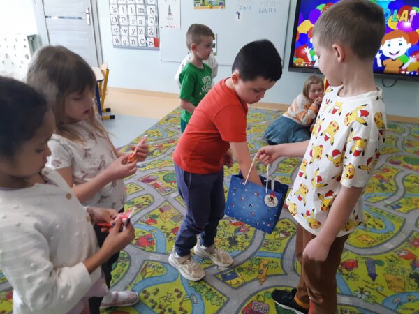 Fabian dzieli się z dziećmi urodzinowymi łakociami.