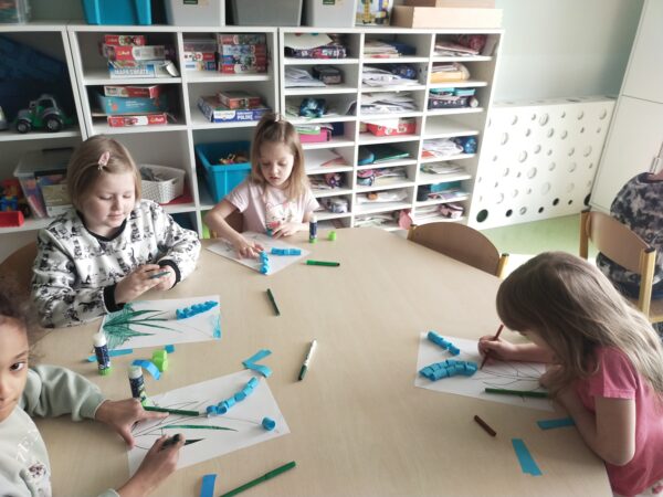 Dziewczynki kolorują flamastrami listki szafirka