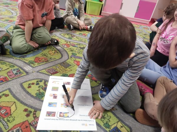 Krzyś wybiera właściwy obrazek do wyrażenia "Good morning"