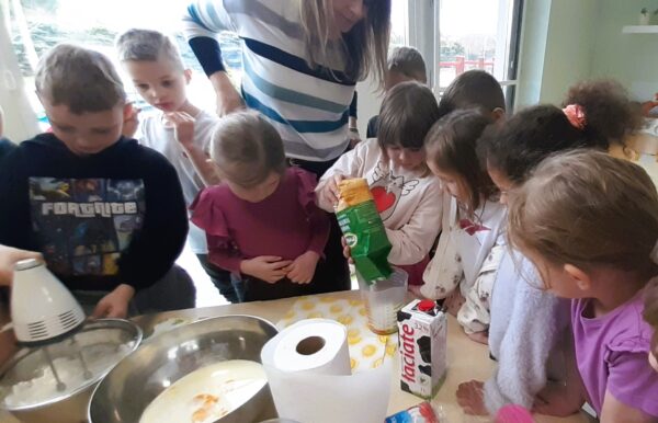 Misie z pomocą wychowawczyń robią gofry.