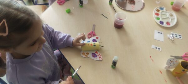 Ula maluje farbami skrzydła motyla