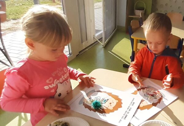 Misie wykonują pracę plastyczną z wykorzystaniem różnorodnych faktur włóczki.