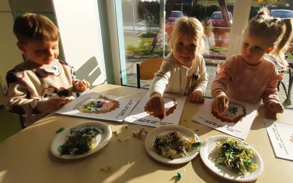 Misie wykonują pracę plastyczną z wykorzystaniem różnorodnych faktur włóczki.