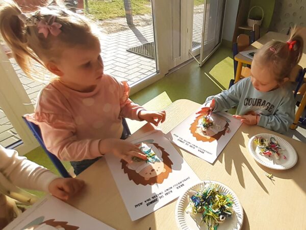 Misie wykonują pracę plastyczną z wykorzystaniem różnorodnych faktur włóczki.