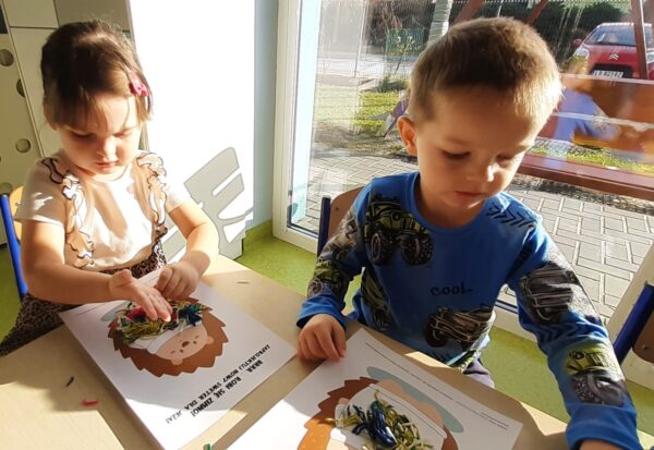 Misie wykonują pracę plastyczną z wykorzystaniem różnorodnych faktur włóczki.