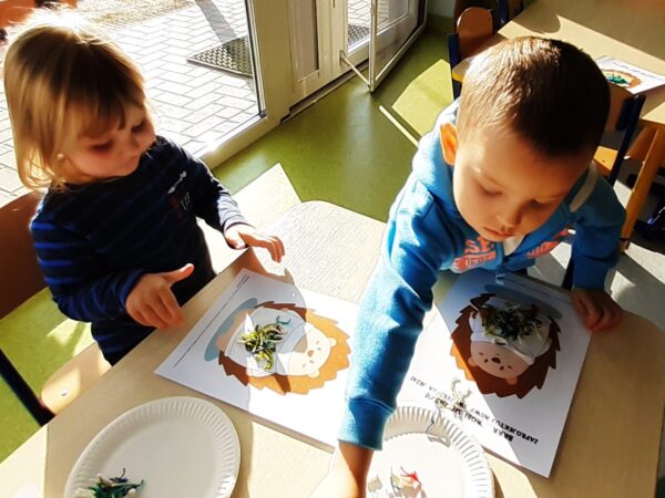 Misie wykonują pracę plastyczną z wykorzystaniem różnorodnych faktur włóczki.