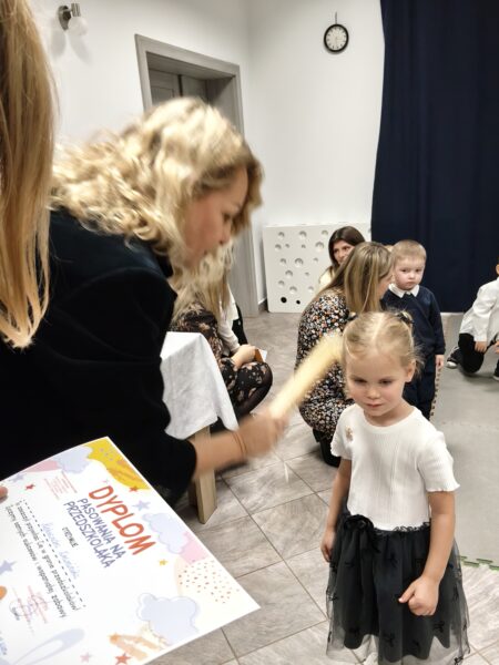 Oleńka zostaje pasowana przez panią dyrektor na przedszkolaka.