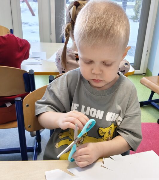 Filip poznaje pierwsze etapy nauki wycinania nożyczkami.