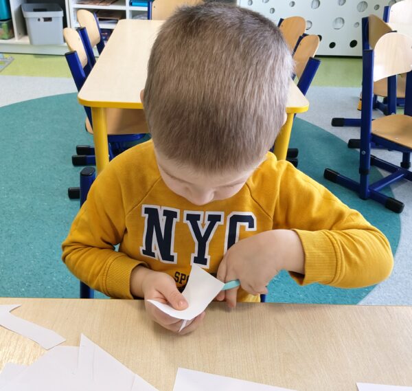 Kubuś poznaje pierwsze etapy nauki wycinania nożyczkami.