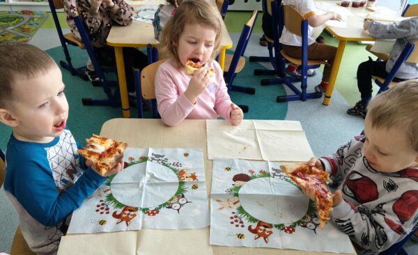 Misie biorą udział we wspólnej degustacji pizzy.