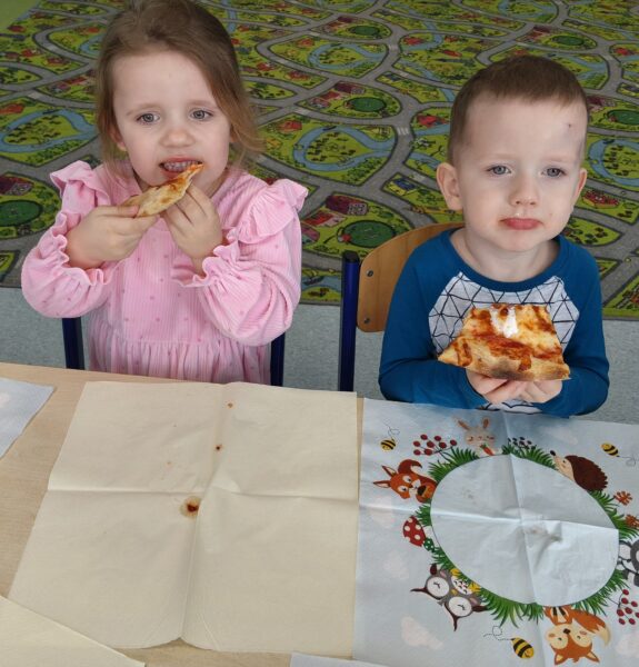 Misie biorą udział we wspólnej degustacji pizzy.