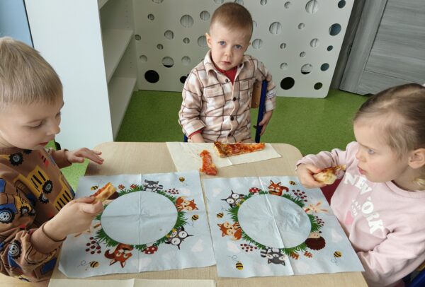 Misie biorą udział we wspólnej degustacji pizzy.
