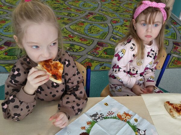 Misie biorą udział we wspólnej degustacji pizzy.